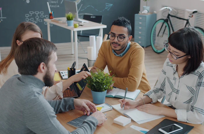 Diverse group of colleagues in a relaxed conversation around a table