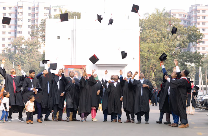 Graduates in caps and gowns celebrating, tossing their caps in the air