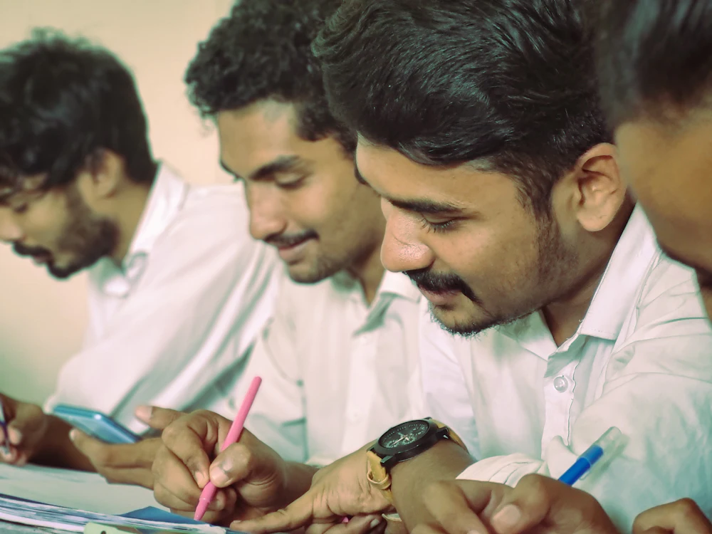Group of engineering students in Kerala, India reviewing their coursework together